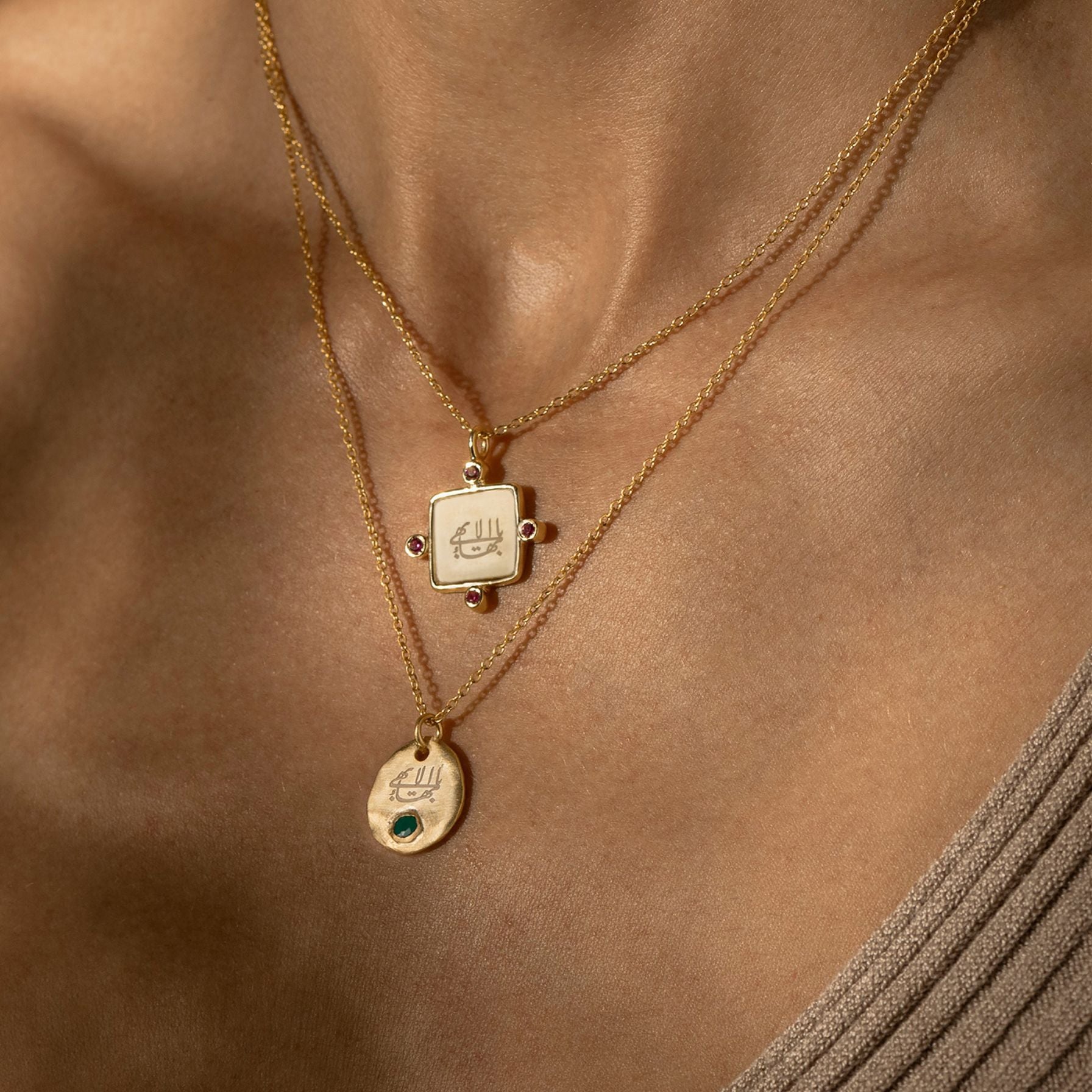 Gold necklaces with bahai pendants on a person's neck against a brown background