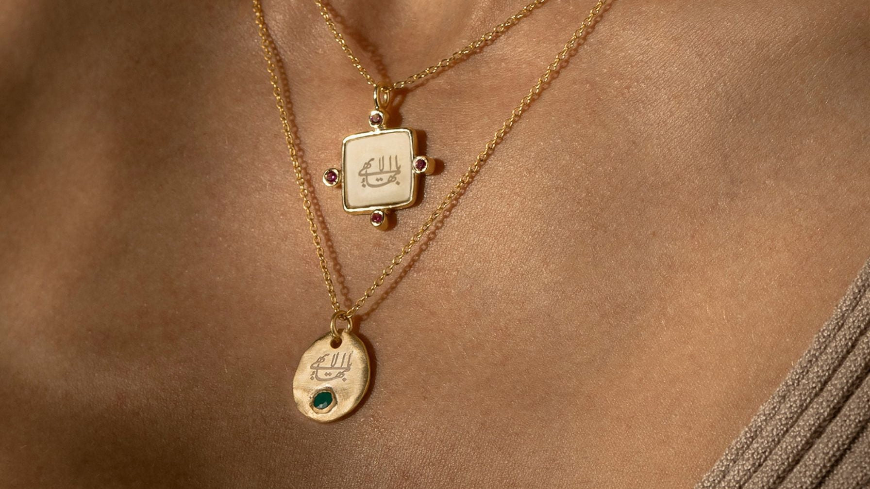 Gold necklaces with bahai pendants on a person's neck against a brown background