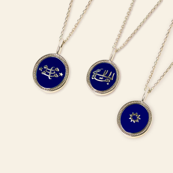 Three circular pendant necklaces with bespoke enamel and bahai faith symbols on a white background.