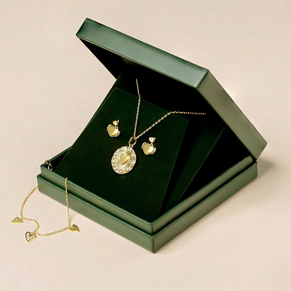 A jewelry set in a green box, featuring a gold necklace with a heart pendant, matching heart-shaped earrings, and a bracelet adorned with heart-shaped charms. This love heart set embodies timeless style and elegance.