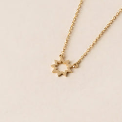 A Brightest Star Necklace, featuring a stunning gold nine-pointed symbol pendant, beautifully displayed on a plain light surface.