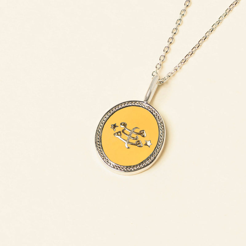 Silver necklace with a yellow pendant featuring the Ringstone Symbol, displayed on a pale background.